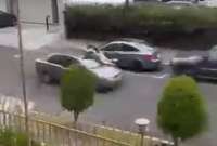 El hombre aferrado al capó de su auto. 