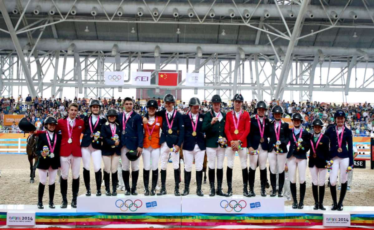 Macarena, segunda de la derecha, posa feliz en el podio con el elenco norteamericano que consigui&oacute; la medalla de bronce en salto ecuestre por equipos. Foto: Cortes&iacute;a: Xinhua