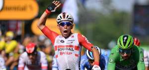 El ciclista australiano Caleb Ewan (c.), levanta su brazo derecho en se&ntilde;al de victoria por la obtenci&oacute;n del primer lugar en la etapa 16 del Tour de Francia.