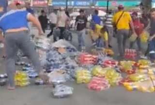 Ciudadanos ayudan a recolectar bebidas que cayeron de un camión en Guayaquil