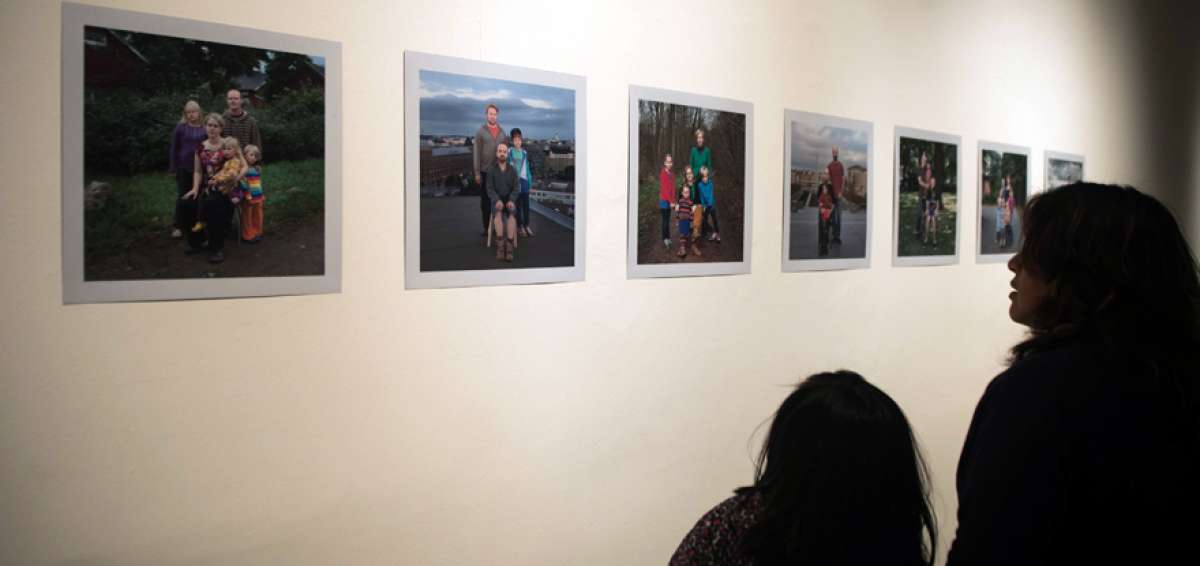 Una ni&ntilde;a y su madre miran las fotograf&iacute;as de familias diversas que pertenecen a la muestra Soy Paisaje. 