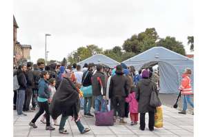 Refugiados hacen fila a la espera de atenci&oacute;n m&eacute;dica en la estaci&oacute;n Eisenhuettensatdt, en el este de Alemania. Foto: AFP