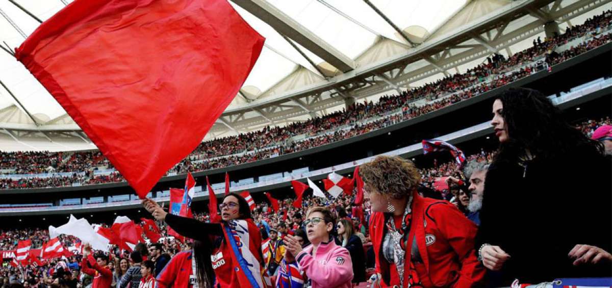 Aficionadas del Atl&eacute;tico de Madrid exhiben banderas rojiblancas en las gradas, durante el encuentro por la liga ante el FC Barcelona.