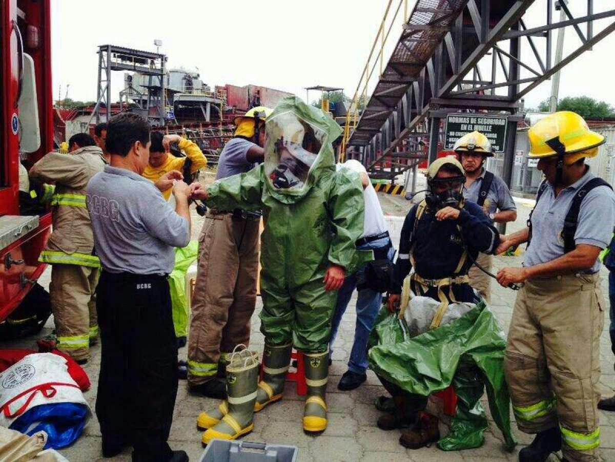 Con m&aacute;scaras y trajes que cubren todo el cuerpo, los expertos trabajan en la terminal portuaria. Foto tomada del Twitter @cups_fire_gye