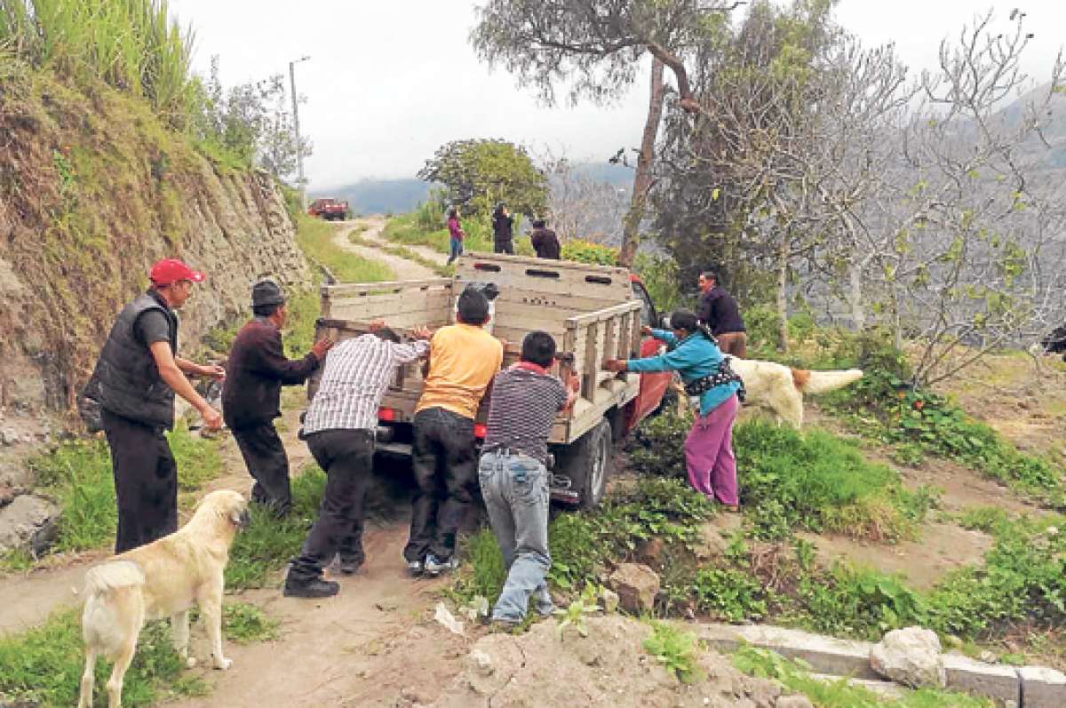 Es una tarea com&uacute;n, los vecinos se dan una mano para empujar una camioneta que qued&oacute; atascada en el recodo de uno de los caminos estrechos y sinuosos de esta comunidad rural. FOTO: ROBERTO CHAVEZ | El Tel&eacute;grafo