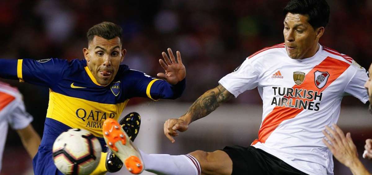 El jugador de Boca Juniors, Carlos T&eacute;vez (izq.), disputa el bal&oacute;n con Enzo P&eacute;rez, de River, en la semifinal de ida.
