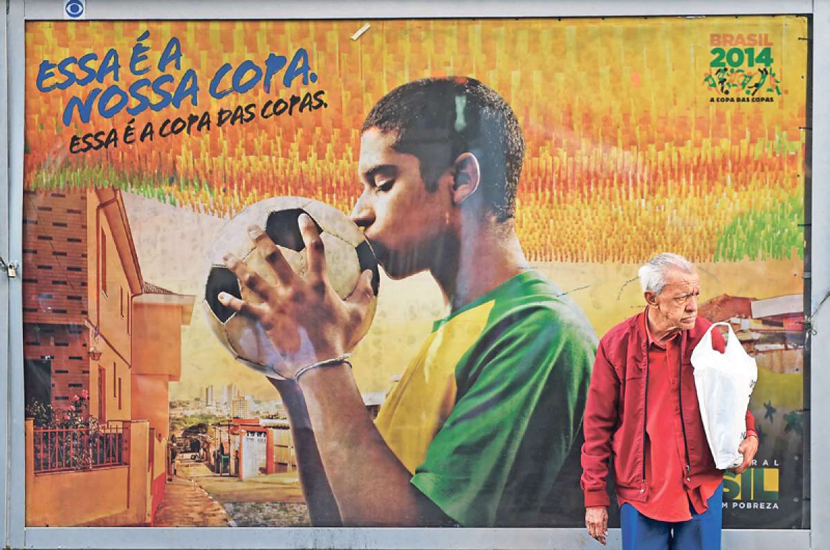 Un se&ntilde;or espera en Sao Paulo teniendo de fondo a uno de los miles de murales en alusi&oacute;n del Mundial que adornan las calles de Brasil. 