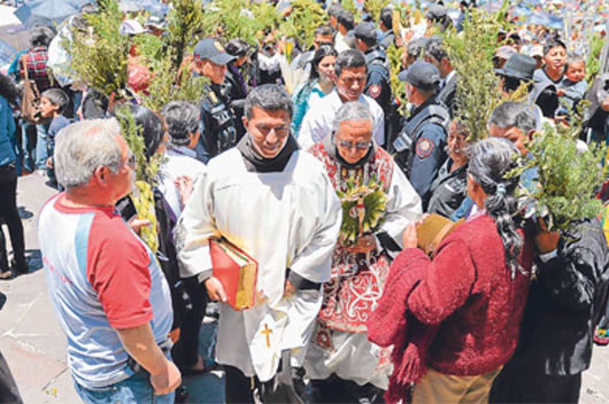 Los feligreses recibieron al p&aacute;rroco de la iglesia San Francisco con ramos elaborados con totora y romero para hacerlos bendecir, en lugar de arreglos hechos con hojas de palmas de cera. FOTO: MIGUEL JIM&Eacute;NEZ.