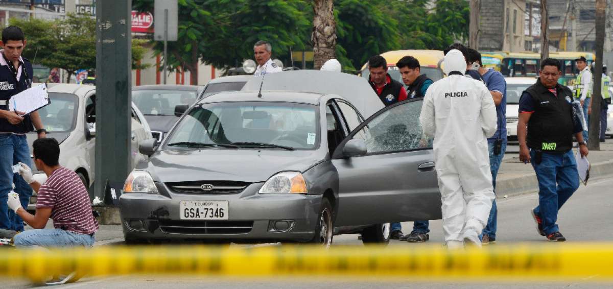 La Polic&iacute;a cerc&oacute; el sitio del crimen para recoger evidencias. El cuerpo qued&oacute; dentro del veh&iacute;culo.