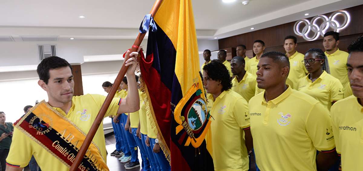 Esteban Enderica (i) realiza el tradicional Pase de la Bandera, ante 28 deportistas que participaron la ma&ntilde;ana de ayer en la ceremonia de abanderamiento que se realiz&oacute; en el auditorio principal del Comit&eacute; Ol&iacute;mpico Ecuatoriano.