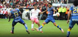 Luis Andr&eacute;s Chicaiza (c), volante de creaci&oacute;n de Liga de Quito, realiza una asistencia ante la marca de dos defensas.