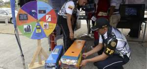 El agente de tr&aacute;nsito Jos&eacute; Cadena arregla un adhesivo en un peque&ntilde;o bus de transporte interprovincial.