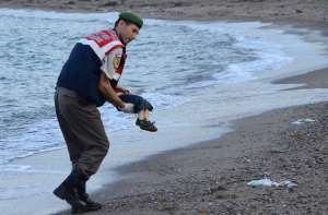 Imagen de un agente turco cargando el cuerpo de un ni&ntilde;o migrante que muri&oacute; ahogado.