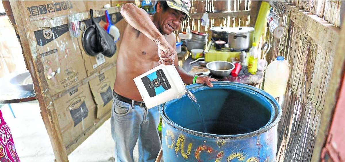 Un ciudadano residente en el barrio El Guasmito, de la parroquia rural El Morro, almacena agua.   