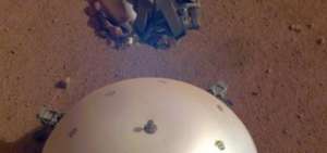 Esta imagen, tomada el 19 de marzo de 2019 por una c&aacute;mara en el m&oacute;dulo de aterrizaje Mars InSight de la NASA, muestra el escudo t&eacute;rmico del veh&iacute;culo, que cubre su sism&oacute;metro, la  Estructura Interna de Experimentos S&iacute;smicos y la superficie marciana en el fondo.