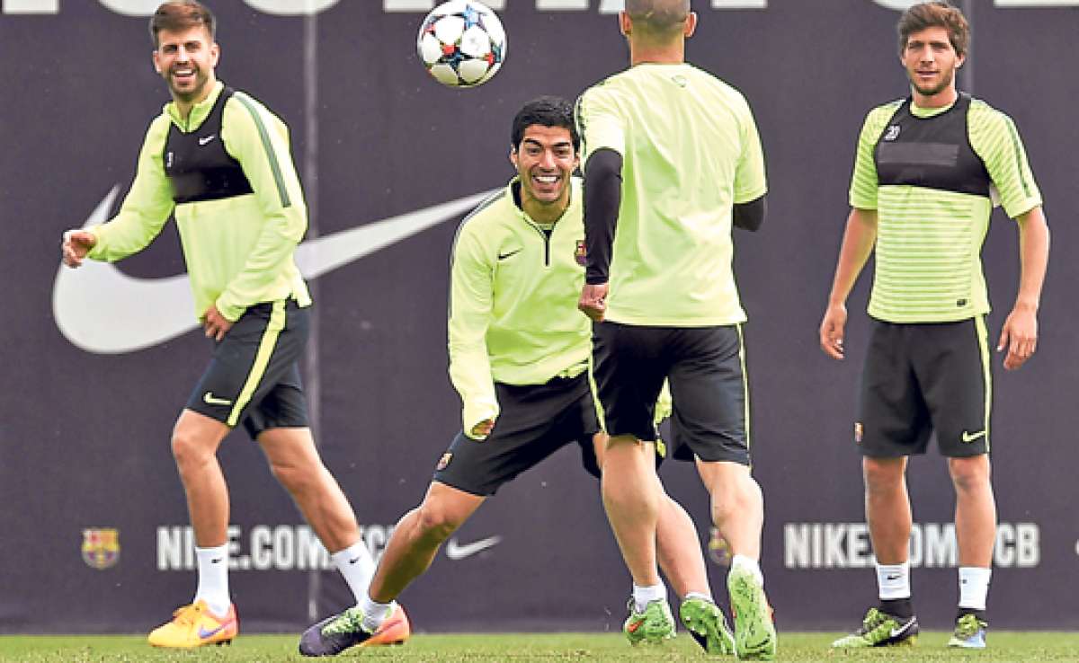El delantero Uruguayo Luis Su&aacute;rez (centro) domina la pelota junto a Javier Mascherano (de espaldas). Atr&aacute;s los observan Gerard Piqu&eacute; (izq.) y Sergi Roberto (der.). Foto: AFP