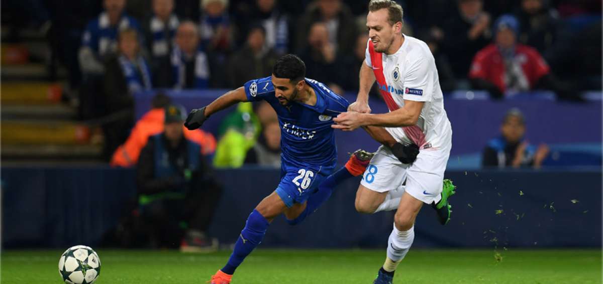 El delantero argelino Riyad Mahrez (i), autor del segundo tanto del Leicester, intenta escaparse del defensa belga Laurens De Bock, del Brujas. 