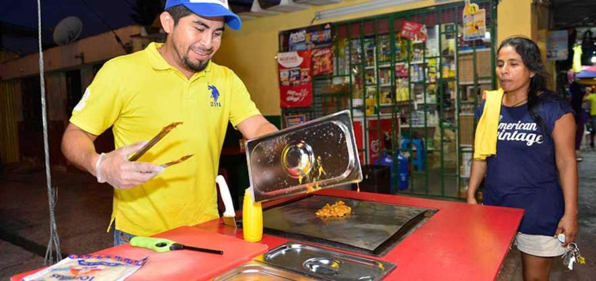 Manu fabric&oacute; su propio puesto de trabajo en donde ubica los ingredientes y prepara los tacos, burritos y pasteles; tambi&eacute;n hizo las mesas. Su lugar de trabajo es muy colorido.