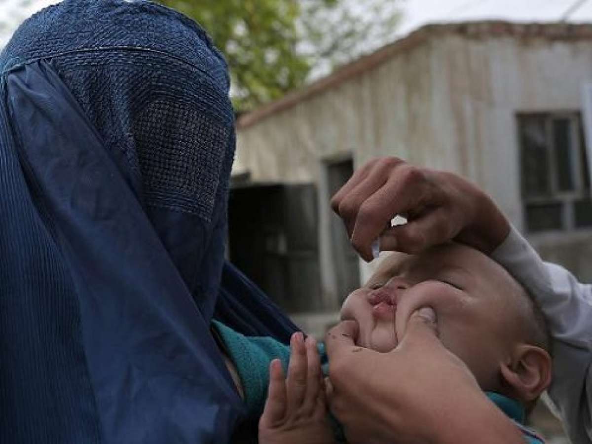 Una madre sostiene a su hijo mientras recibe la vacuna de la polio en Ghazni, Afganist&aacute;n. Foto: AFP