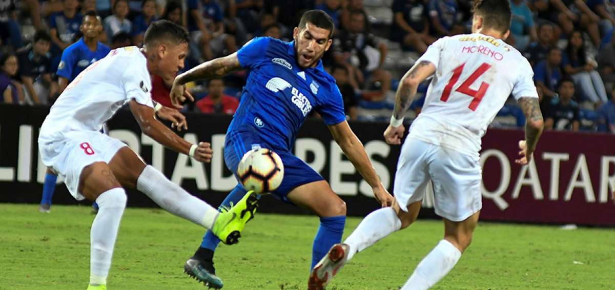 El jugador Leandro Vega (c), de Emelec, disputa el bal&oacute;n con Jes&uacute;s Bueno (i), del Deportivo Lara, en compromiso desarrollado en Guayaquil.