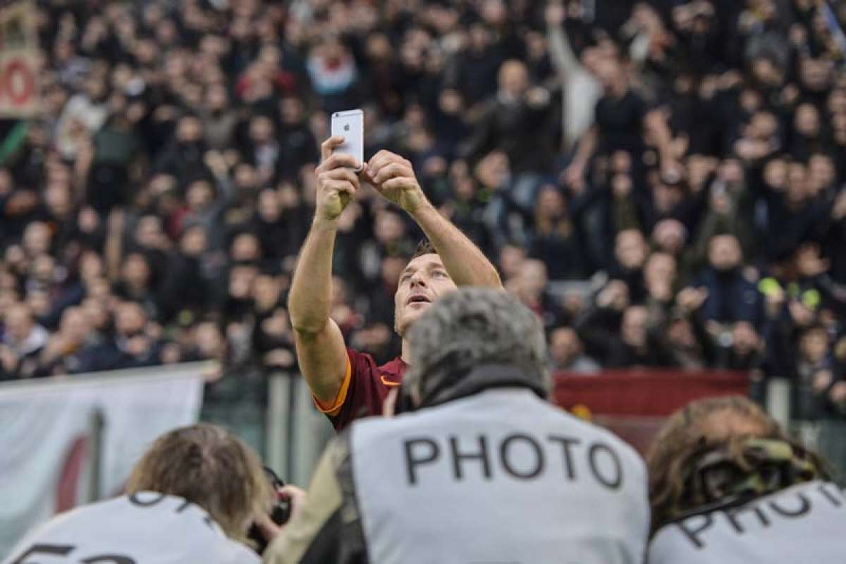 Totti pidi&oacute; un celular a un miembro del cuerpo t&eacute;cnico para la foto. Foto: Agencia AFP