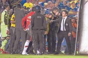 El t&eacute;cnico Marcelo Gallardo (der.) intenta controlar a sus jugadores minutos despu&eacute;s de que les lanzaran gas pimienta cuando se aprestaban para entrar a la cancha, luego del entretiempo. Fotos: AFP