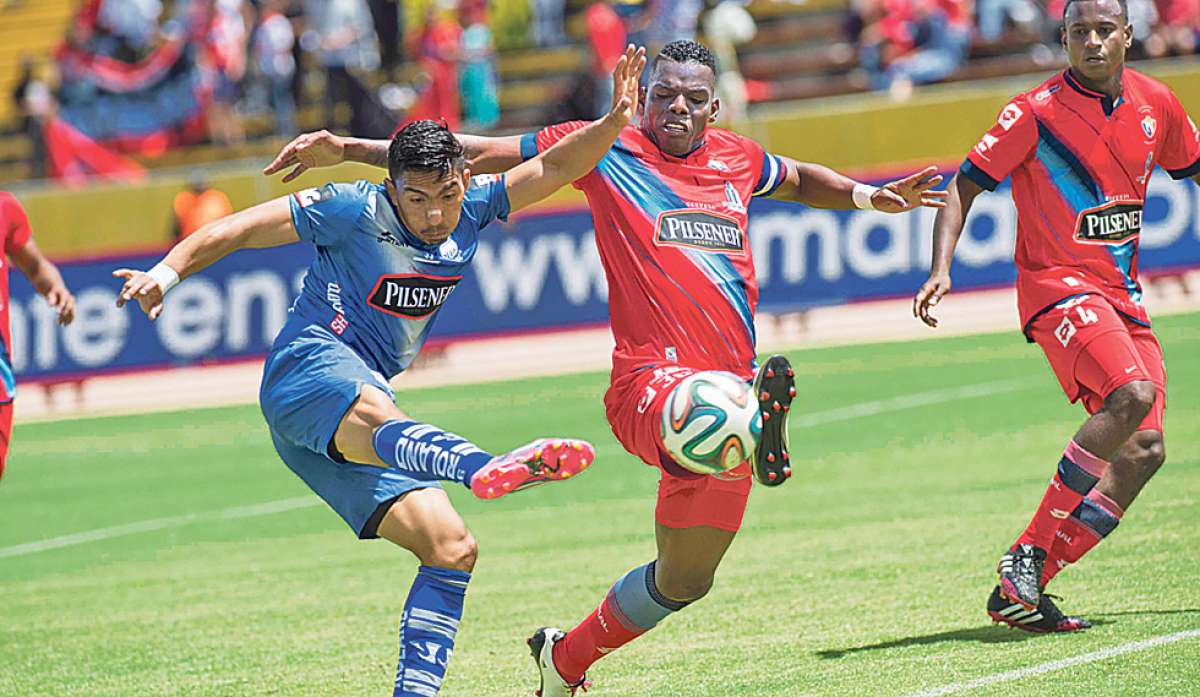 El volante de Emelec, &Aacute;ngel Mena (iz.) remata la pelota ante la marca del zaguero de El Nacional, Geovanny Caicedo (d.) en el juego de ayer en Quito. Foto: Fernando Sandoval / El Tel&eacute;grafo.