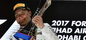 &rarr;El piloto finland&eacute;s, Valtteri Bottas, de la escuder&iacute;a Mercedes, celebra en el podio con el trofeo como vencedor en el Gran Premio de Abu Dabi.