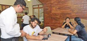 H&eacute;ctor Zambrano (izquierda) atiende a los clientes que pidieron un caf&eacute; irland&eacute;s en el local Kafkafe, en la calle A entre 44 y 45 de Guayaquil. El lugar funciona de lunes a s&aacute;bado de 16:00 a 20:00. 