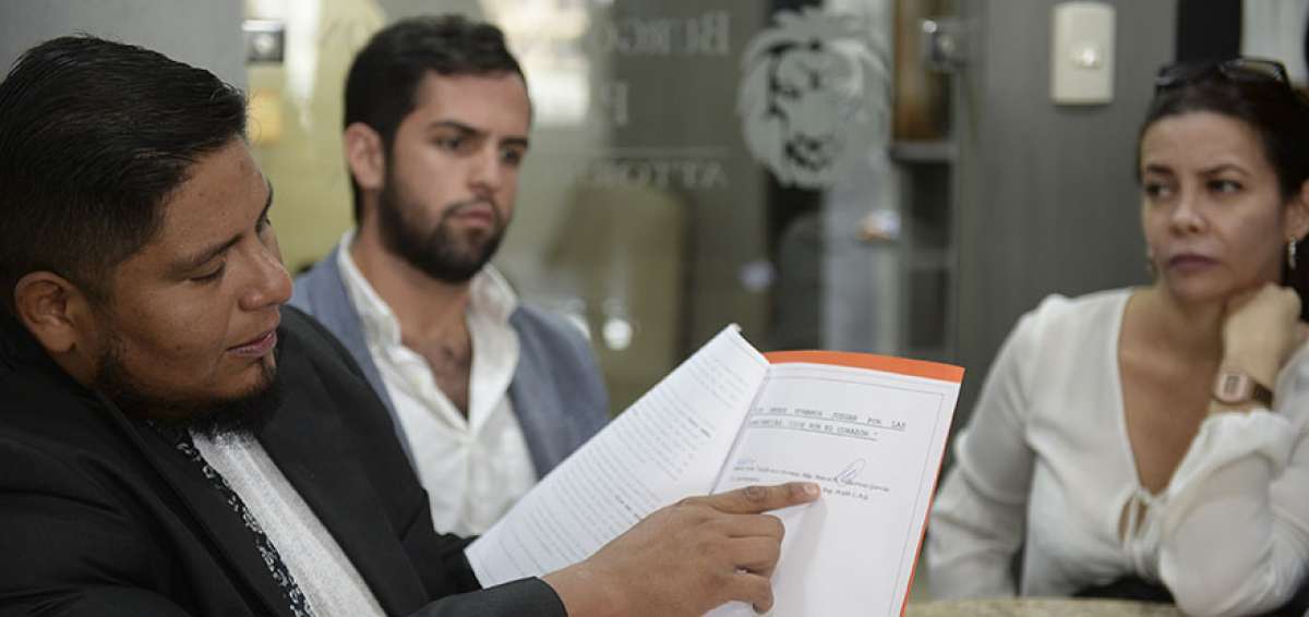 Fausto Valdiviezo Jr. (centro) y el abogado defensor, Pedro Buitr&oacute;n, muestran documentos legales relacionados al proceso de la muerte del periodista.