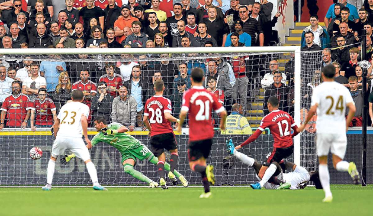 Momento en que el franc&eacute;s Bafetimbi Gomis (en el piso) doblega al arquero argentino Sergio Romero y marca el tanto del triunfo del Swansea. Foto: AFP