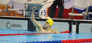 El nadador cuencano Esteban Enderica levanta su brazo derecho tras llegar en el primer lugar de los 1.500 metros libres y cosechar la medalla de oro de los Juegos Suramericanos que se realizan en Cochabamba.