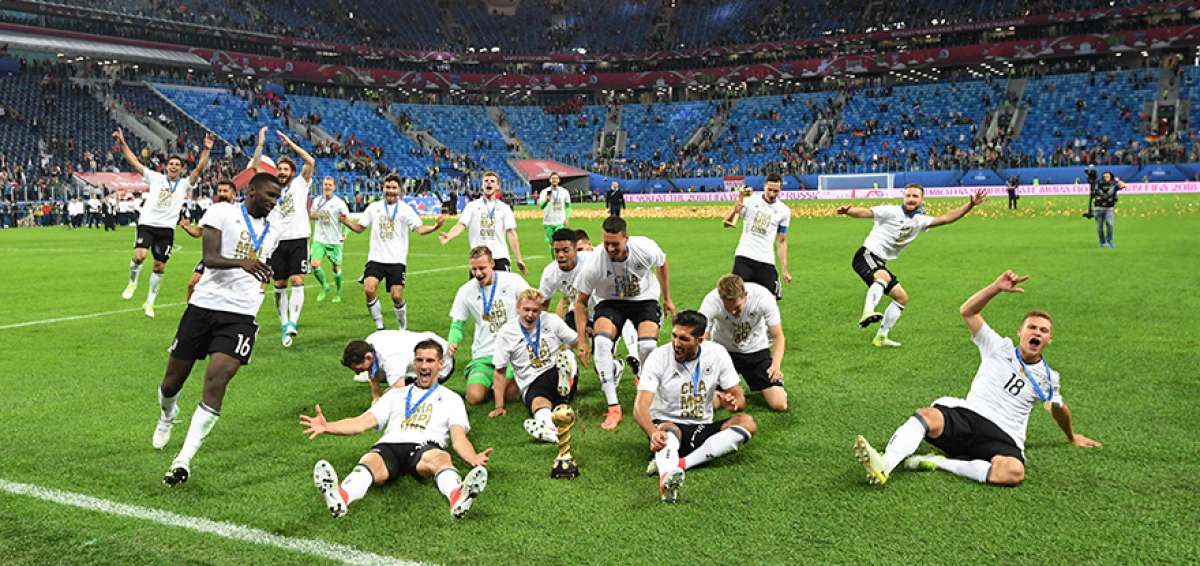 Los jugadores alemanes festejan el t&iacute;tulo de la Copa Confederaciones lanz&aacute;ndose junto al trofeo. 