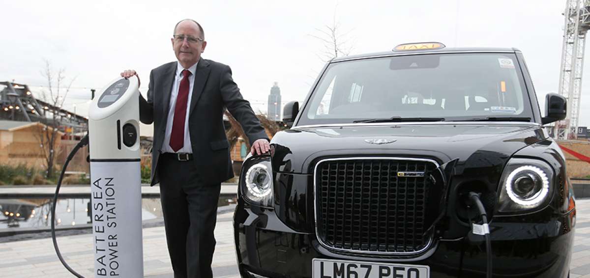 &rarr;El CEO de London EV Company, Chris Gubbey, posa junto con el taxi el&eacute;ctrico, conectado a un cargador en la central el&eacute;ctrica Battersea, Londres.