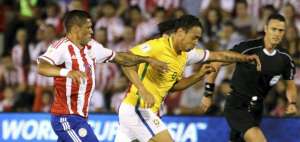 El delantero de Brasil, Ricardo Oliveira, disputa el bal&oacute;n con el volante paraguayo Richard Ortiz.
