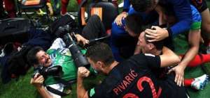 Yuri Cortez no dej&oacute; de hacer fotos pese a verse atrapado bajo la monta&ntilde;a de jugadores.
