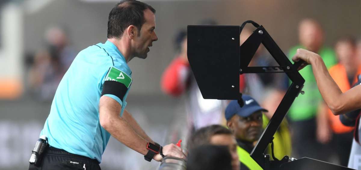 Un &aacute;rbitro observa la repetici&oacute;n de una jugada a trav&eacute;s de un monitor ubicado al pie de la cancha.