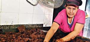 Sobre una gran mesa met&aacute;lica la pasta de cacao es amasada por h&aacute;biles manos de  emprendedoras.
