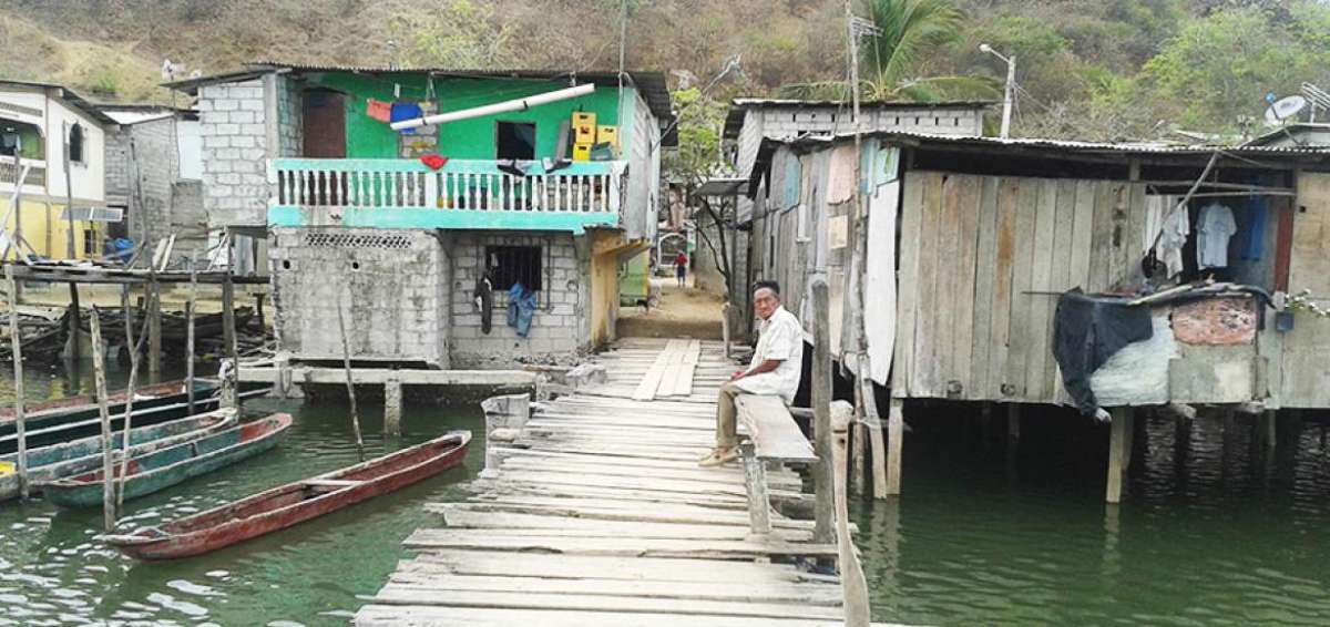 Un muelle de madera conduce a la poblaci&oacute;n que se ubica entre el cerro y el estero.