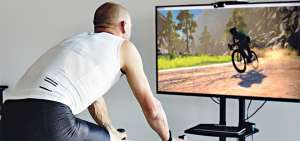 &rarr;Esta imagen referencial muestra a un ciclista en plena competencia virtual. Mientras se pedalea se puede ver el recorrido en un monitor.