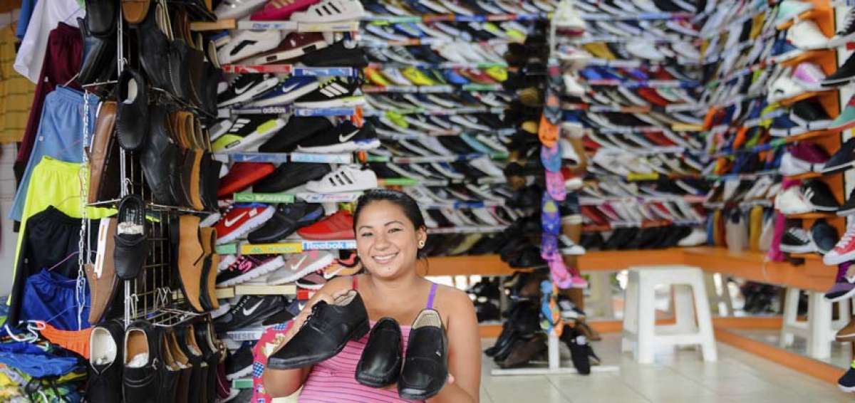 La comerciante Karina Cede&ntilde;o muestra los zapatos que tiene a la venta en su local, Selena Sport, ubicado en la Zona Comercial Tarqui. Anteriormente estaba ubicada en Tarqui, sector que qued&oacute; destruido por el terremoto del 16 de abril. Asegura que ah&iacute; ten&iacute;a m&aacute;s ventas, pero est&aacute; optimista que con el pasar de los d&iacute;as llegar&aacute;n m&aacute;s clientes.