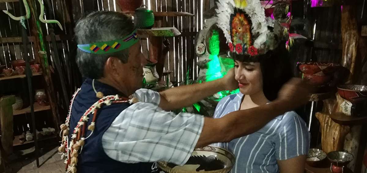 Un gu&iacute;a de Madre Tierra atav&iacute;a a las turistas con elementos propios de su vestimenta, como coronas de plumas.