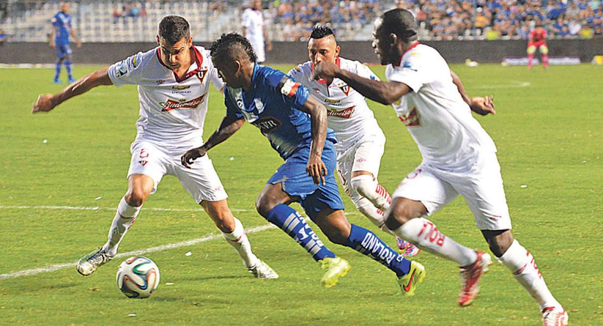 El delantero Miller Bola&ntilde;os (c), de Emelec, intenta eludir la marca de 3 defensas de Liga de Quito, entre ellos N&eacute;icer Reasco (d) -ayer-, en el estadio George Capwell. Foto: Eduardo Escobar / El Tel&eacute;grafo