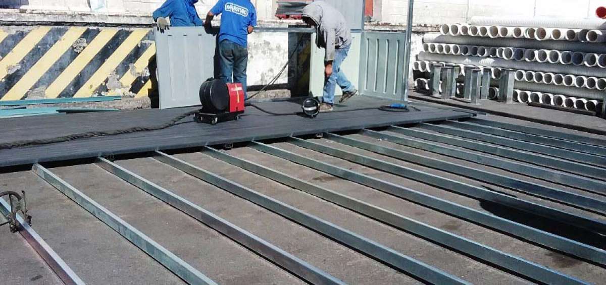 En esta gr&aacute;fica se muestra el montaje de una estructura de 54 metros cuadrados en la empresa Holviplas. Tres personas trabajan en la colocaci&oacute;n de los pisos y de las paredes en polietileno. 
