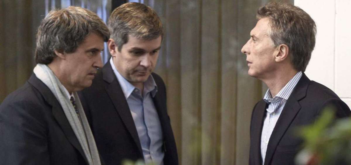 El presidente Mauricio Macri (der.) dialoga con el ministro de Finanzas (izq.), Alfonso Prat, y con el jefe de gabinete (centro), Marcos Pe&ntilde;a, antes de una rueda de prensa.