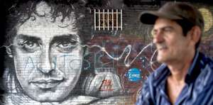 Un ciudadano colombiano camina frente a un mural dedicado al rockero argentino en Cali. Gustavo Cerati se convirti&oacute; en un emblema del rock latinoamericano. Foto: AFP
