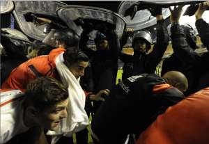 Los jugadores tuvieron que abandonar la cancha custodiados por polic&iacute;as. Foto: AFP