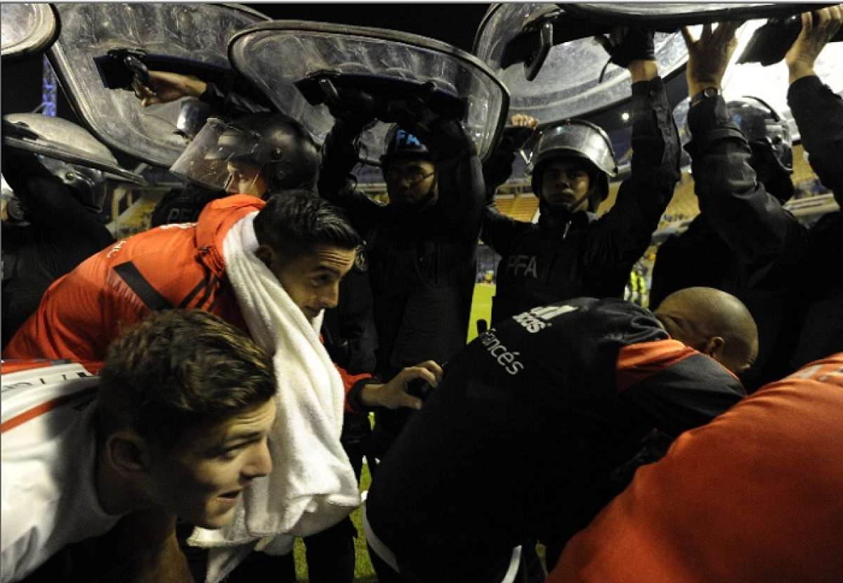 Los jugadores tuvieron que abandonar la cancha custodiados por polic&iacute;as. Foto: AFP