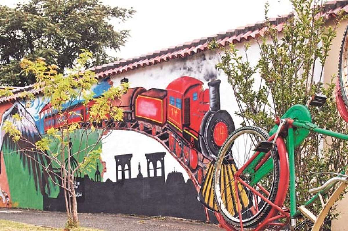 En la ciudadela Chaguarchimbana, en medio de las l&iacute;neas del tren, una especie de monumento a una bicicleta contrasta con el mural de un ferrocarril sobre el perfil de la catedral de Cuenca. Foto: Daniela Le&oacute;n / Para El Tel&eacute;grafo