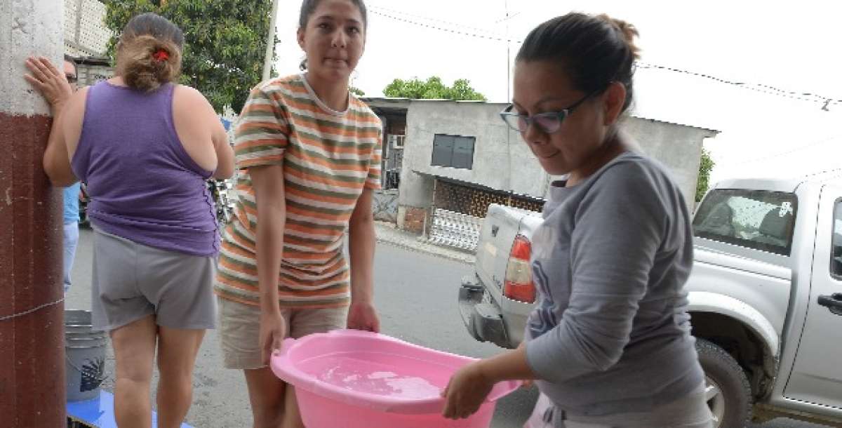 Nicole Fuentes y Carolina Palacios se las ingeniaron para conseguir agua, ayer por la ma&ntilde;ana, en el sector de Flor de Basti&oacute;n. Eduardo Escobar / El Tel&eacute;grafo